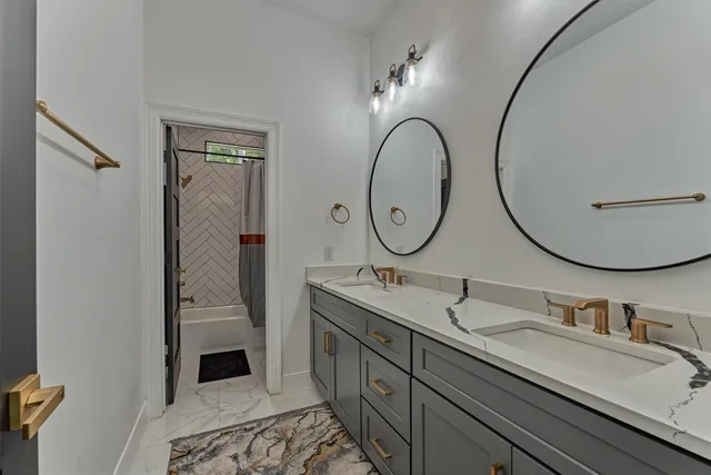 a bathroom with a granite countertop double vanity sink and a mirror