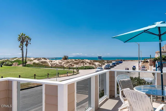 a view of a patio with a table and chairs under an umbrella