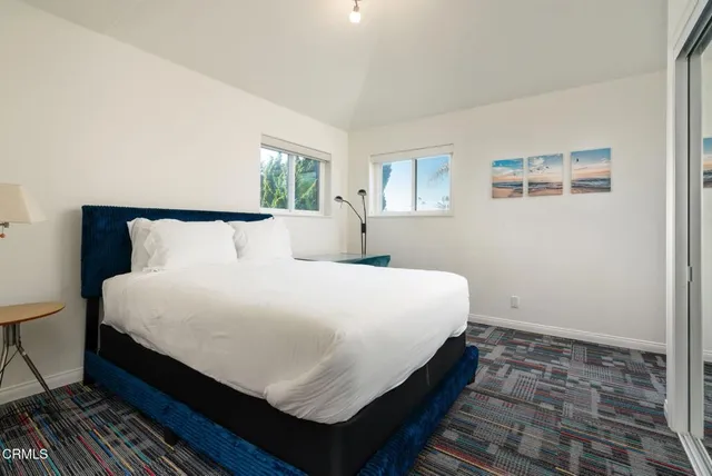 a large bed sitting in a bedroom next to a window