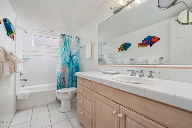 a bathroom with a granite countertop sink mirror vanity and toilet