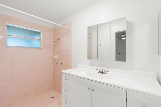 a bathroom with a shower sink and mirror