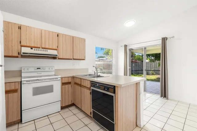 a kitchen with a stove sink and cabinets