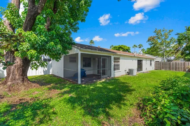 a view of a house with a yard and potted plants