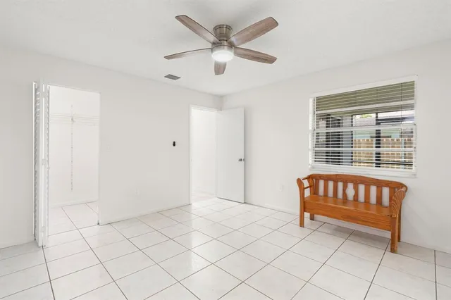 a spacious bedroom with a bed and a ceiling fan