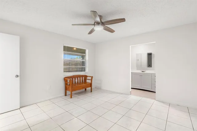 a room with a chair and ceiling fan