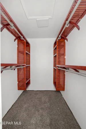 an empty room with a ceiling fan and carpet