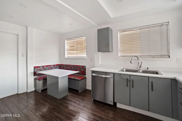 a large white kitchen with a sink and dish washer