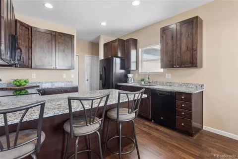 a kitchen with stainless steel appliances granite countertop a kitchen island a table and chairs in it