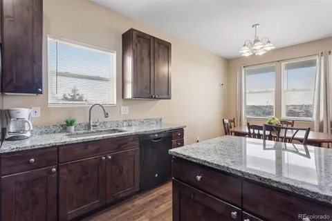 a kitchen with granite countertop a sink dining table and chairs