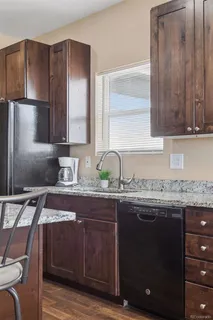 a kitchen with granite countertop a sink and wooden cabinets