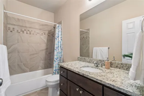 a bathroom with a granite countertop sink toilet and shower