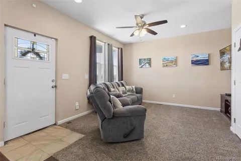 a living room with furniture and a ceiling fan