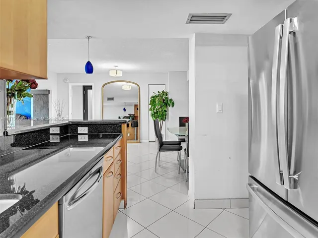 a kitchen with a sink refrigerator and cabinets