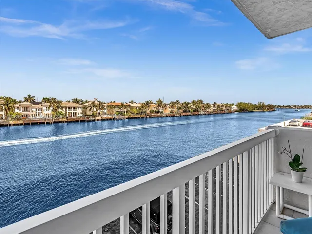 a living room with stainless steel appliances furniture a rug and a kitchen view