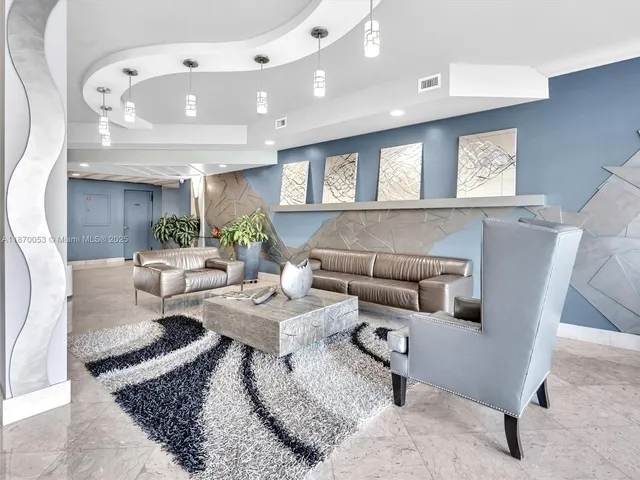 a gym room with lots of furniture and a chandelier