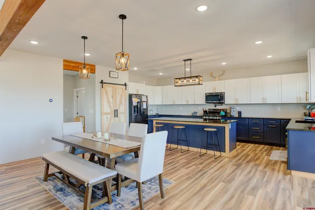 a kitchen with a refrigerator a stove top oven a sink dishwasher and white cabinets with wooden floor