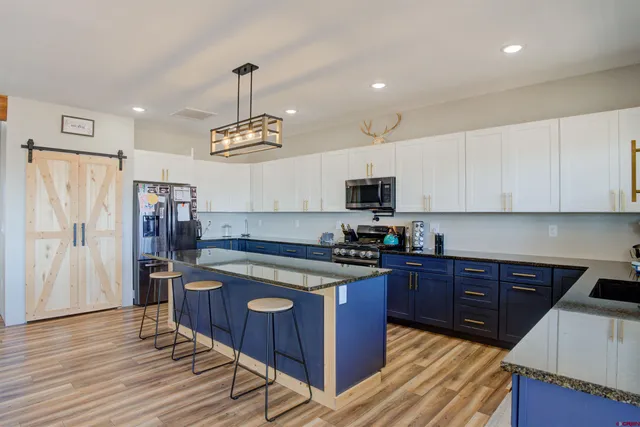 a kitchen with stainless steel appliances granite countertop a stove a refrigerator and a wooden cabinets