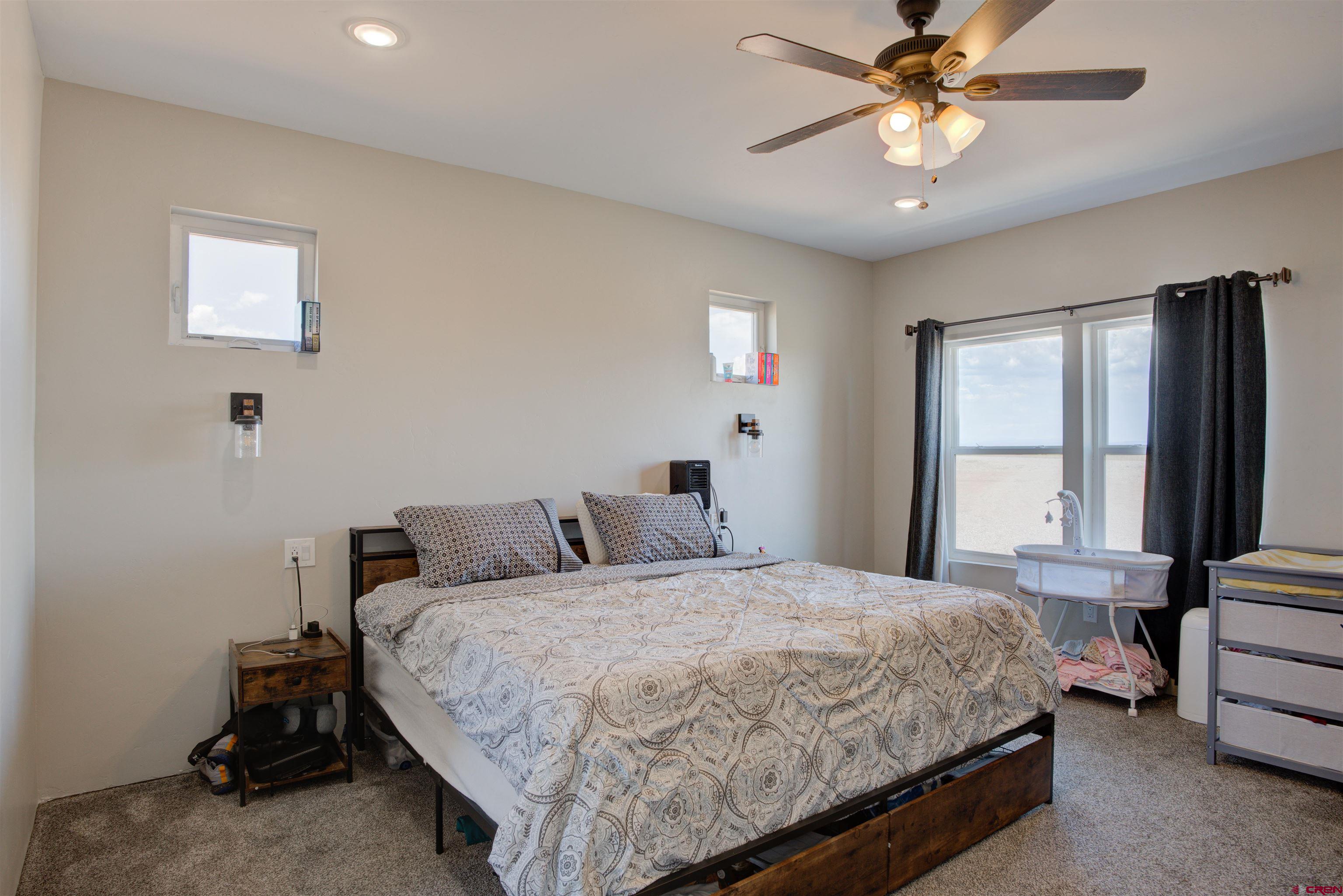 13205 Road 17.9 Loop Cortez, CO 81321 - Photo 18 of 35 a bedroom with a bed and a chandelier