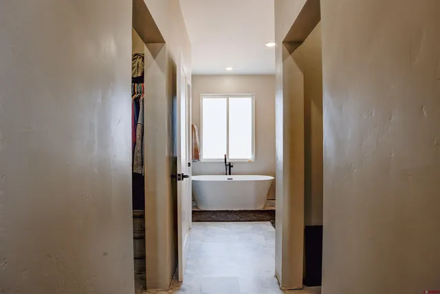 a bathroom with a tub sink and mirror