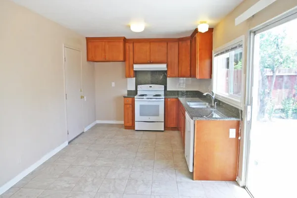 a kitchen with stainless steel appliances granite countertop a stove a sink and a refrigerator