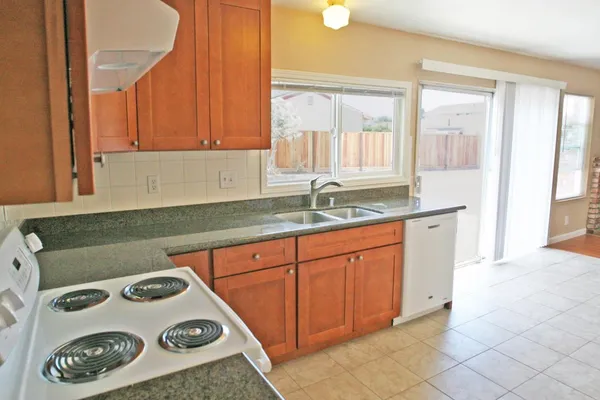 a kitchen with a sink a stove and cabinets