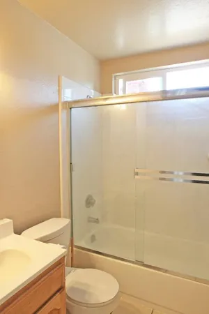 a bathroom with a sink a toilet and shower