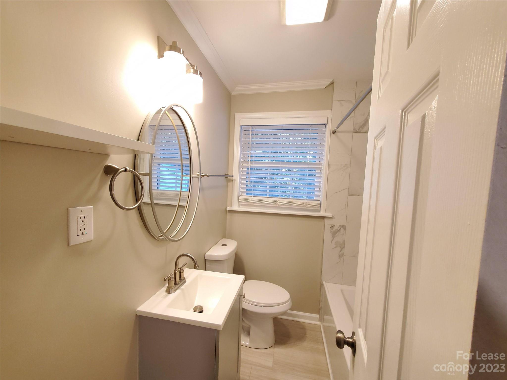 1545 Walton Road, Unit 1547 Charlotte, NC 28208 - Photo 11 of 25 a bathroom with a toilet sink and mirror