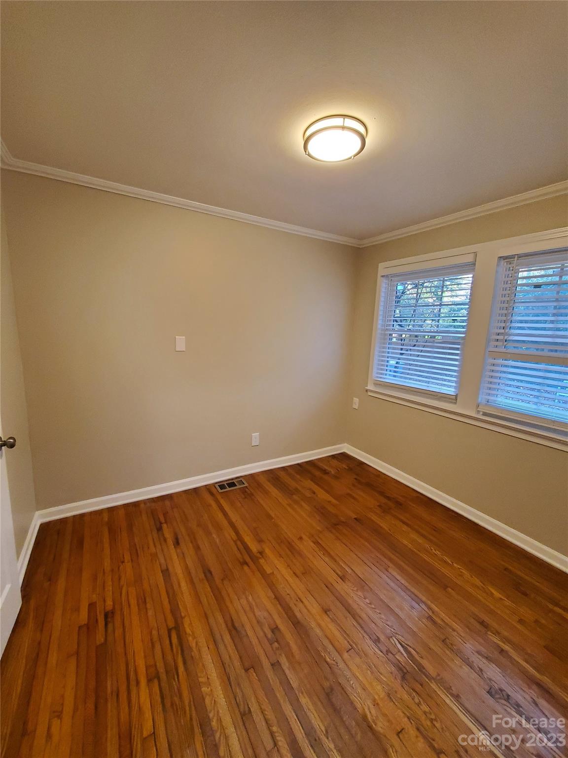 1545 Walton Road, Unit 1547 Charlotte, NC 28208 - Photo 16 of 25 an empty room with wooden floor and windows