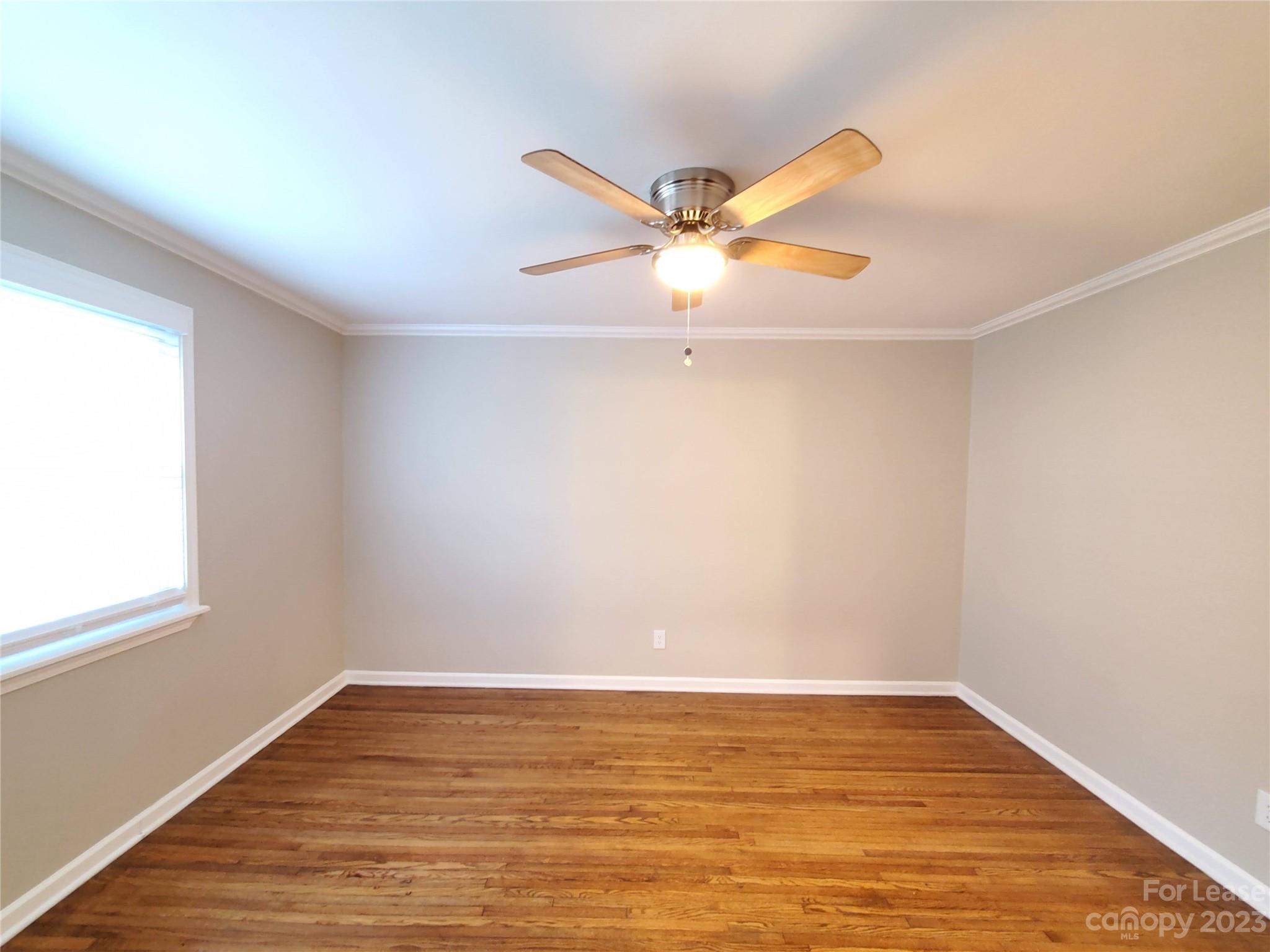 1545 Walton Road, Unit 1547 Charlotte, NC 28208 - Photo 18 of 25 a view of an empty room with wooden floor and a window