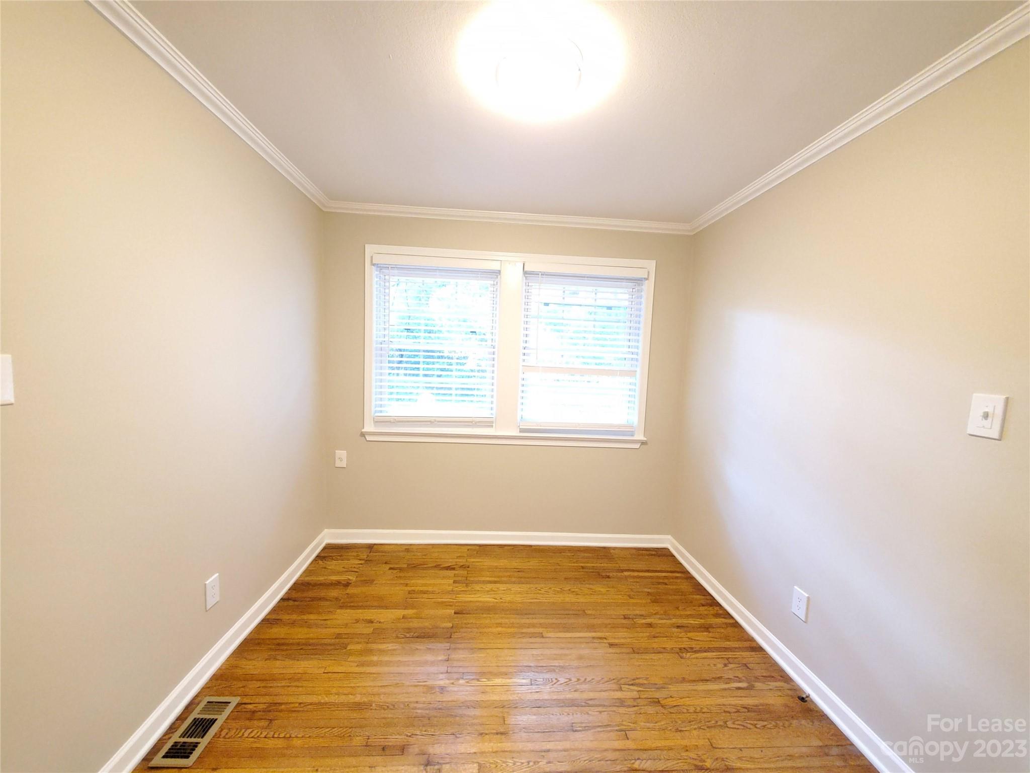1545 Walton Road, Unit 1547 Charlotte, NC 28208 - Photo 23 of 25 a view of an empty room with wooden floor and a window