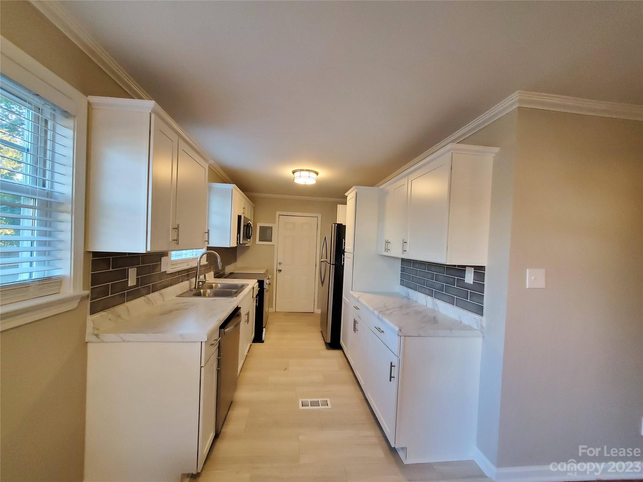 1545 Walton Road, Unit 1547 Charlotte, NC 28208 - Photo 8 of 25 a kitchen with stainless steel appliances granite countertop a sink and cabinets with wooden floor