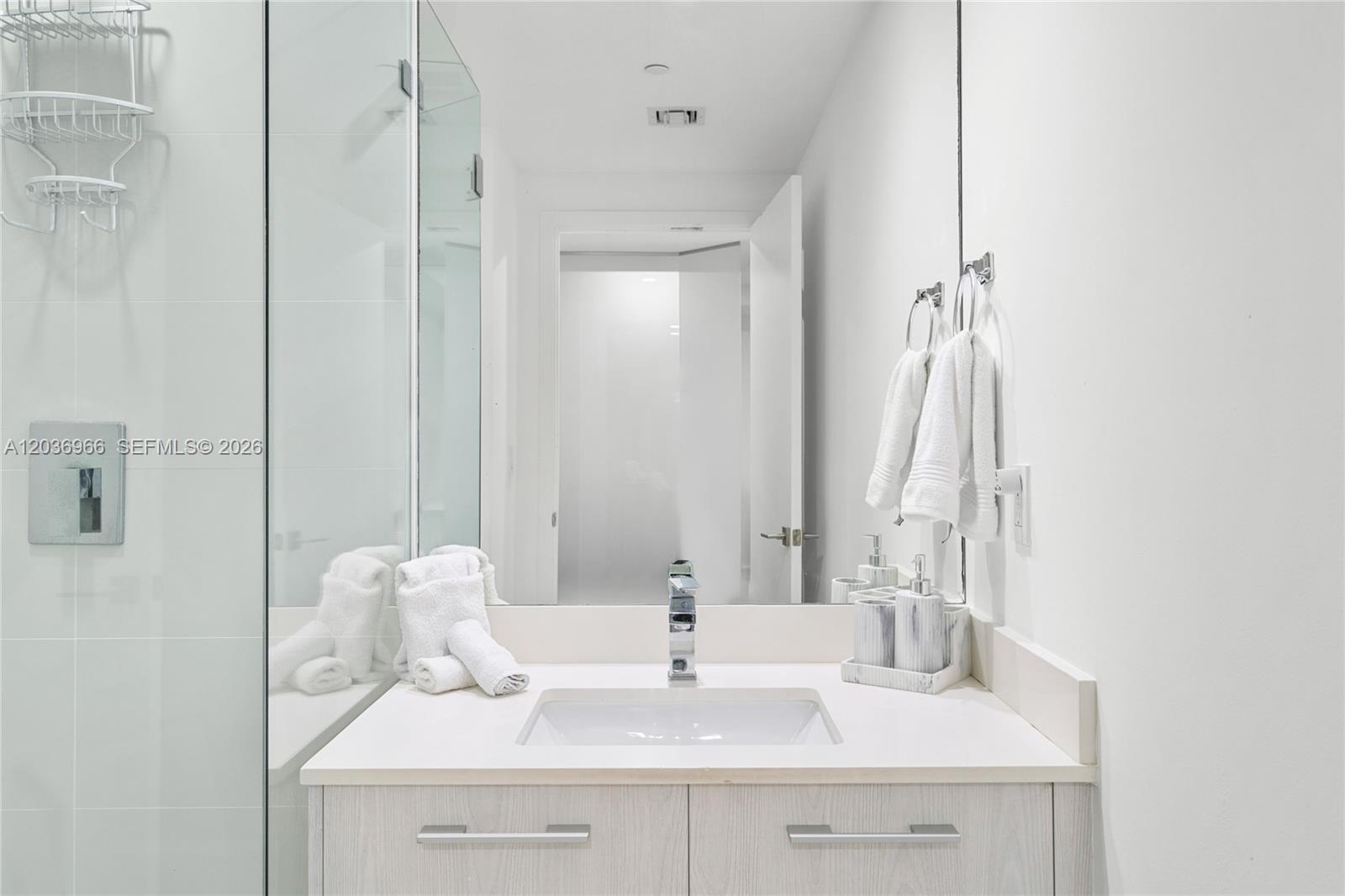 55 Southwest 9th Street, Unit 1904 Miami, FL 33130 - Photo 19 of 66 a bathroom with a sink vanity and a mirror