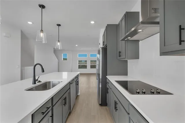 a kitchen with a sink a refrigerator and wooden floor
