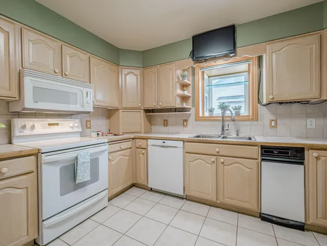 a kitchen with white cabinets white appliances and sink