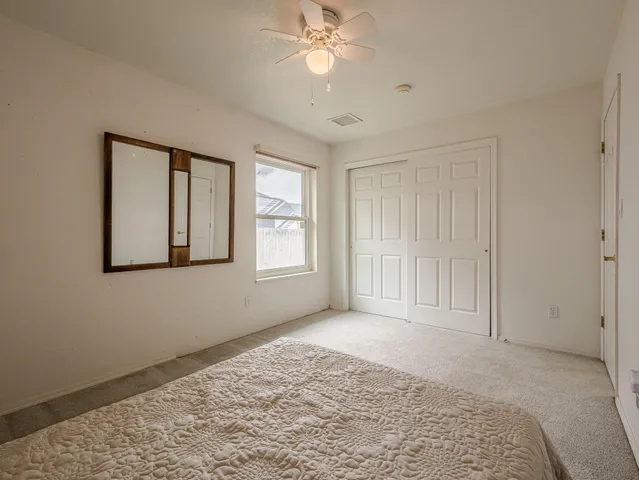 a view of empty room with window and ceiling fan
