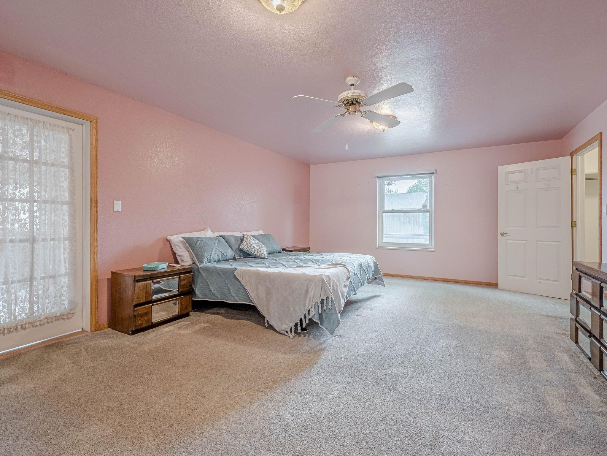 526 North Oak Street Fruita, CO 81521 - Photo 26 of 42 a spacious bedroom with a bed and a chandelier