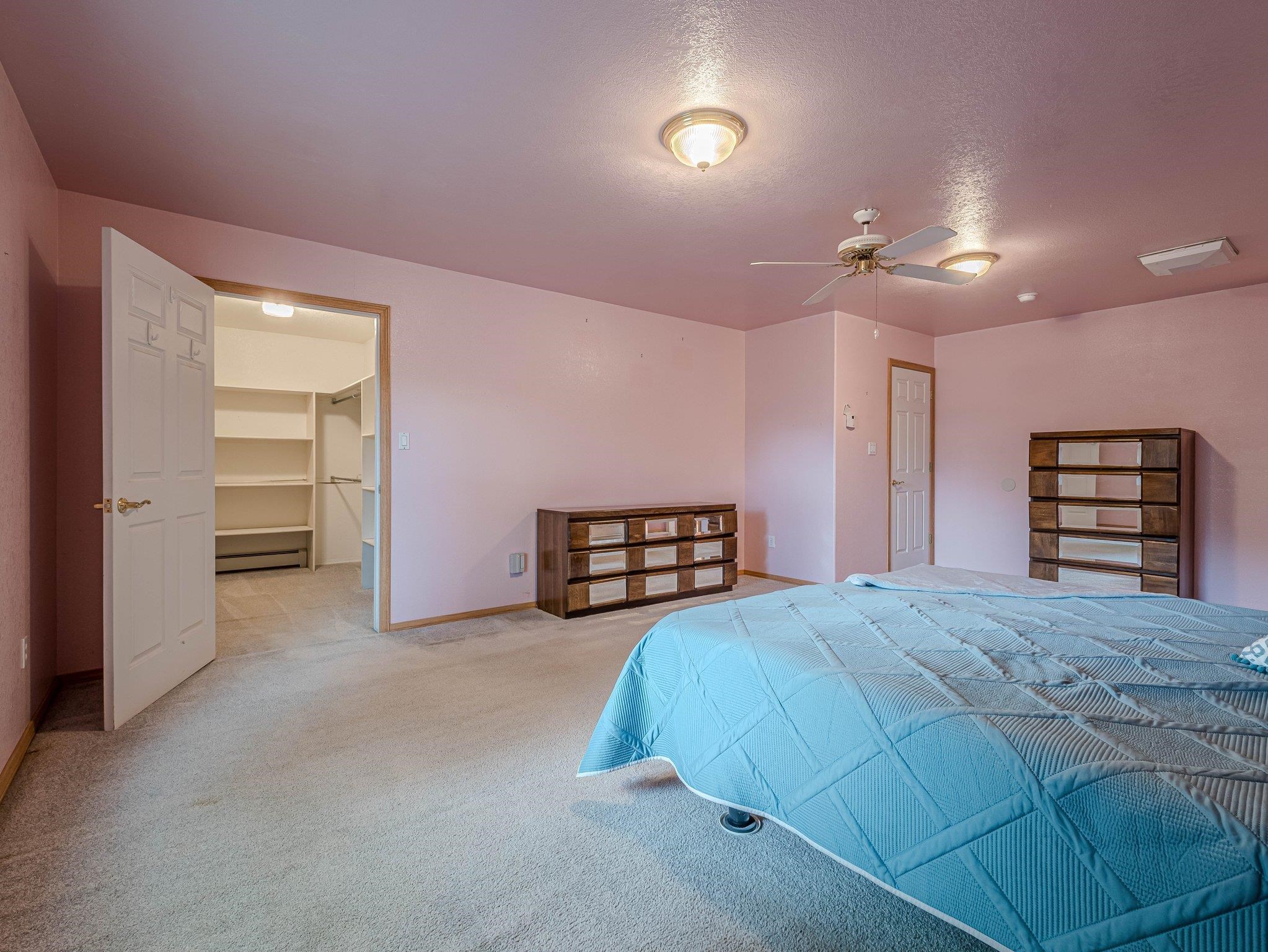 526 North Oak Street Fruita, CO 81521 - Photo 27 of 42 a spacious bedroom with a bed and a chandelier