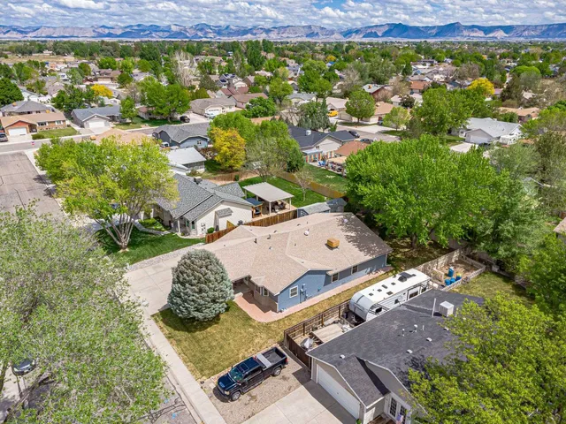 an aerial view of a residential houses with yard