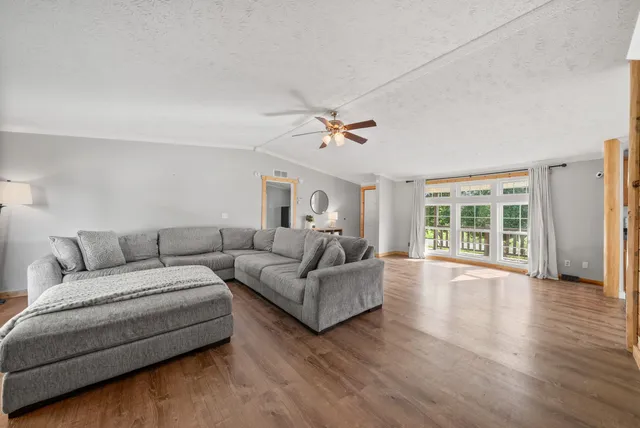 a kitchen with stainless steel appliances kitchen island granite countertop a stove top oven a sink dishwasher a dining table and chairs with wooden floor