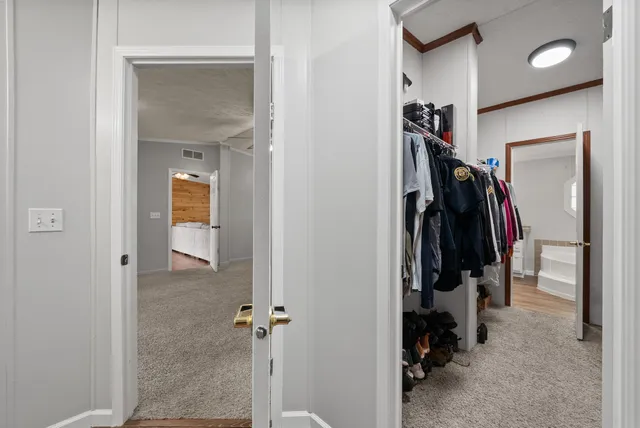 a view of walk in closet with clothes and shoes