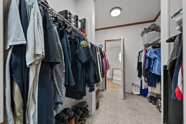 a view of walk in closet with clothes