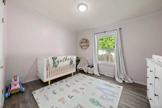 a view of a bedroom with baby bed and closet
