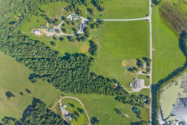 an aerial view of a residential houses with outdoor space and street view