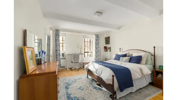 a bedroom with furniture and a rug