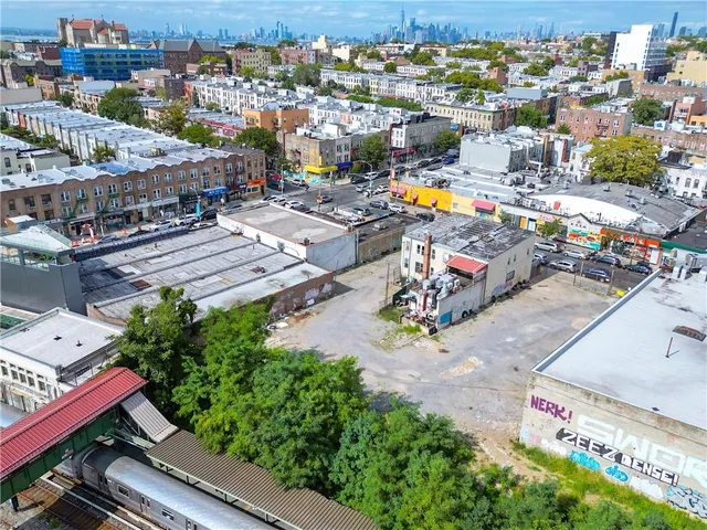 an aerial view of a city with lots of residential buildings ocean and mountain view in back