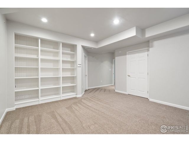 a view of an empty room with a cabinet and wooden floor