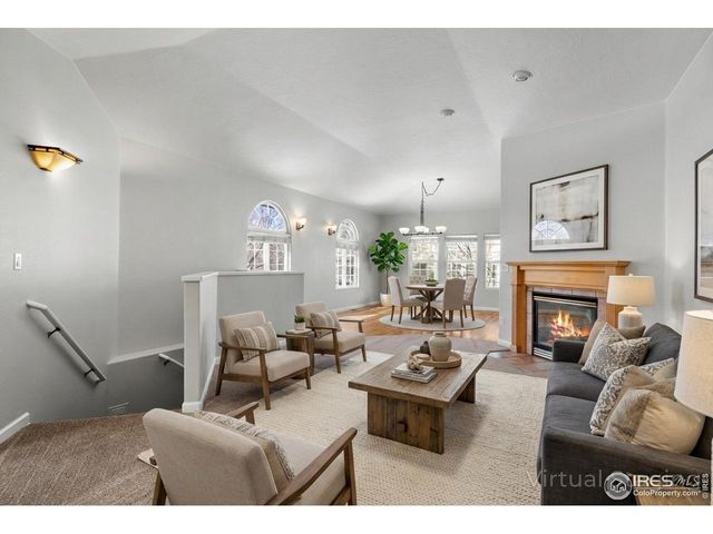 a living room with furniture a fireplace and a chandelier