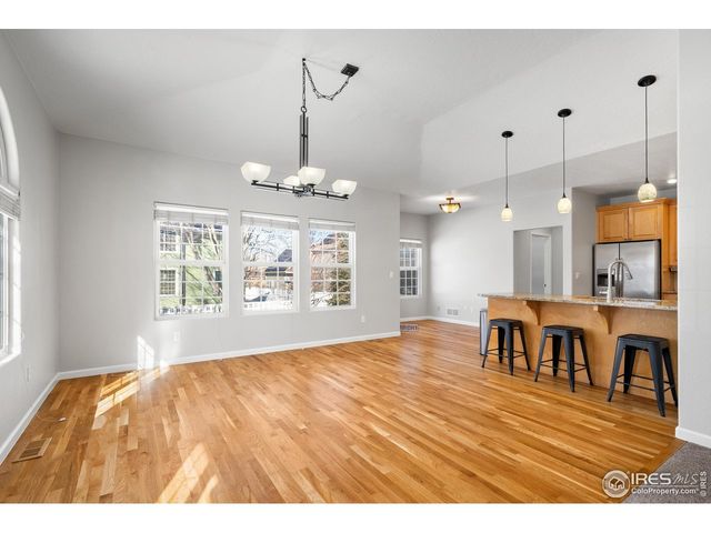 a view of dining room and livingroom with furniture wooden floor a chandelier