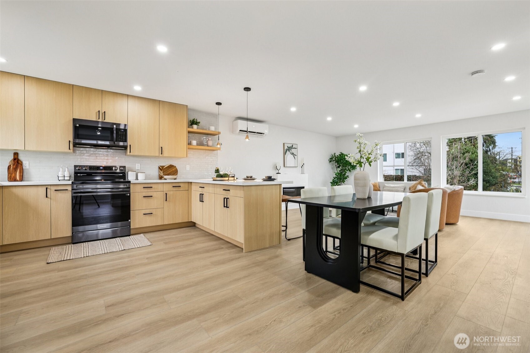 7719 Renton Avenue South, Unit B Seattle, WA 98118 - Photo 13 of 35 a kitchen with stainless steel appliances kitchen island granite countertop a table chairs sink and cabinets