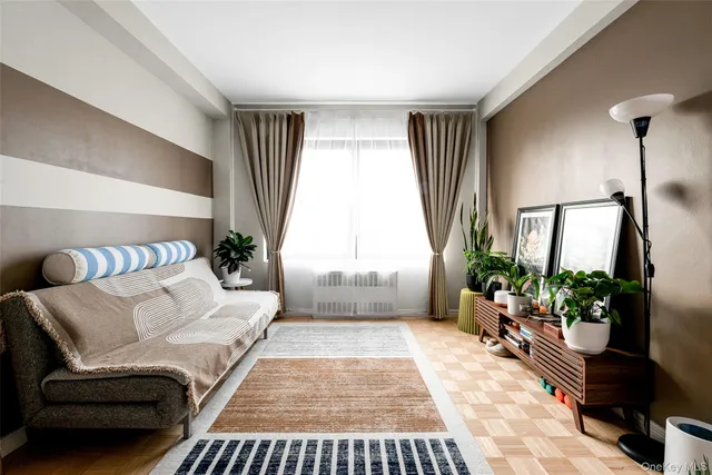 a living room with furniture kitchen view and a potted plant